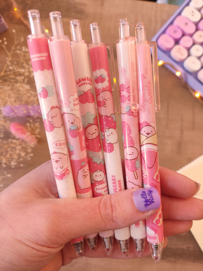 Gros plan sur le embout mignon d'un stylo fantaisie dinosaure et fraise.