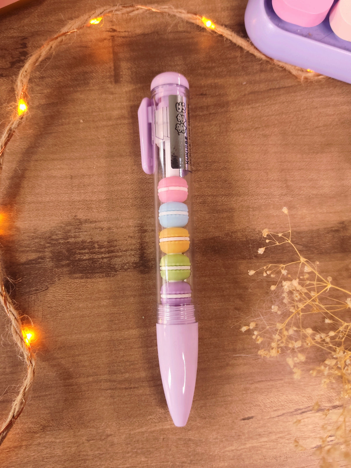 Stylo gel noir kawaii avec figurines de macarons pastel amovibles pour la rentrée.