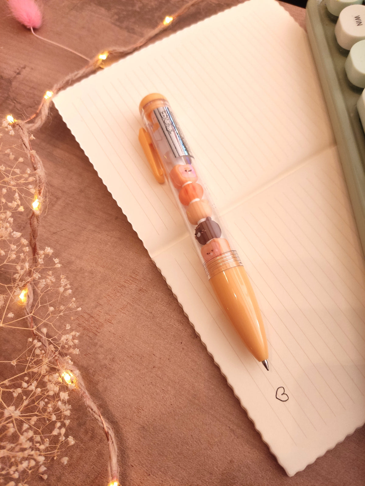 Prise de notes fluide avec le stylo ourson flottant sur un cahier d'école.