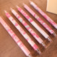 Collection de stylos gel noirs kawaii motifs dinosaure et fraise pour la rentrée des classes.