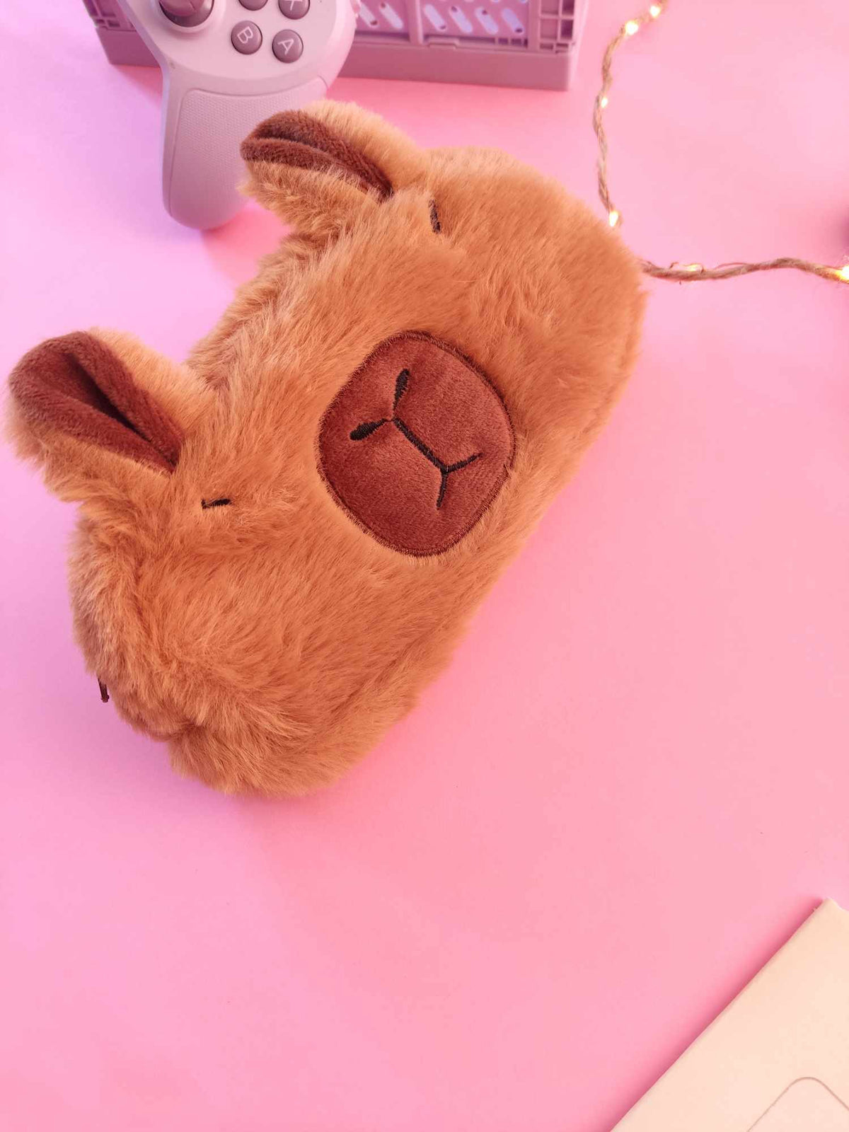 Zoom sur le tissu doux effet doudou de la trousse peluche capybara.