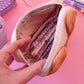 Compartiment de la trousse gâteau chat rempli de stylos et matériel scolaire.