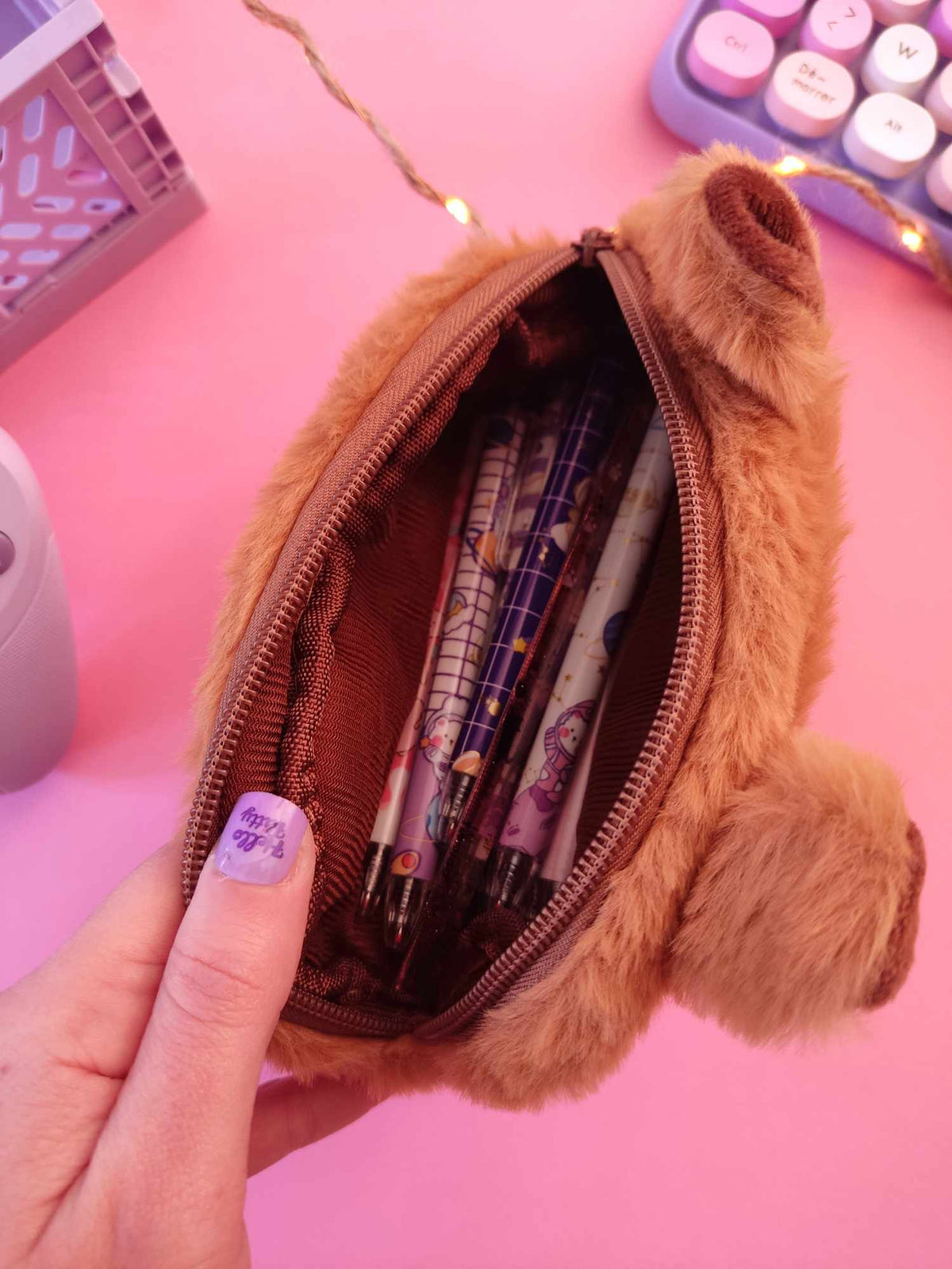 Grand compartiment de la trousse capybara rempli de matériel scolaire.